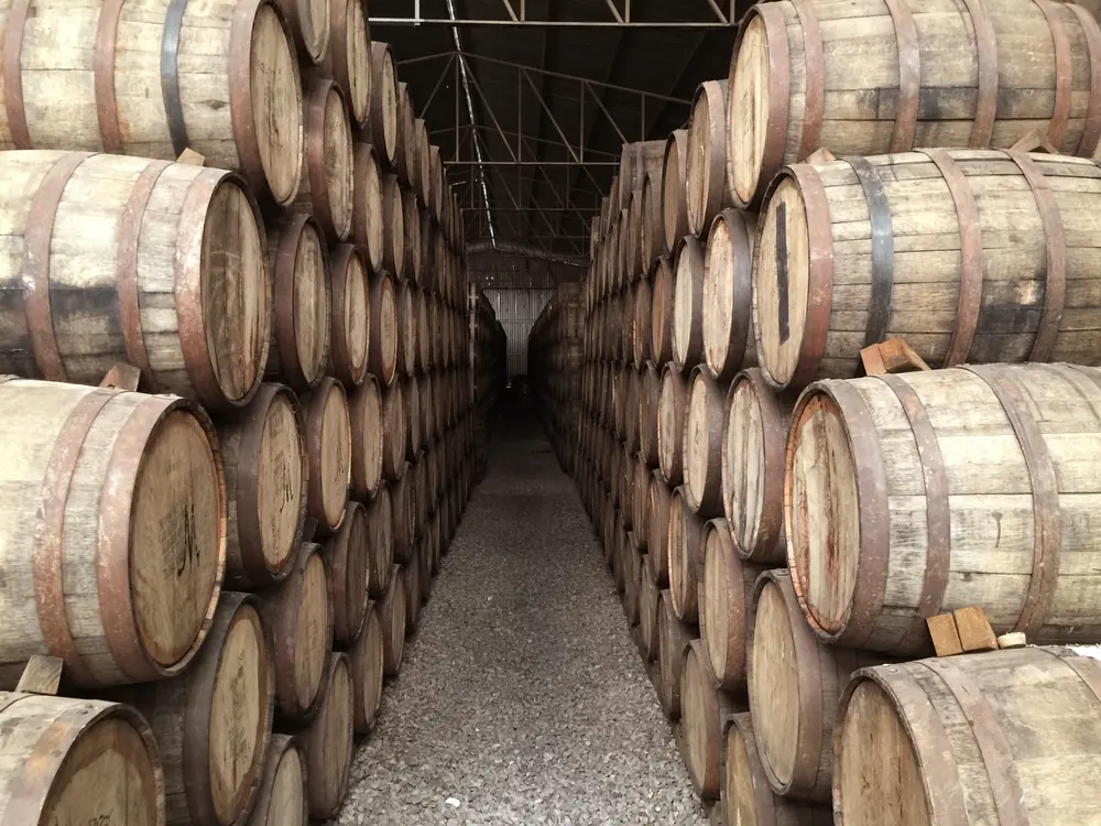 An aisle of whisky casks racked inside a bonded warehouse